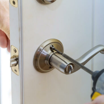 stock-photo-handyman-repair-the-door-lock-in-worker-s-hands-installing-new-door-locker-1164157879